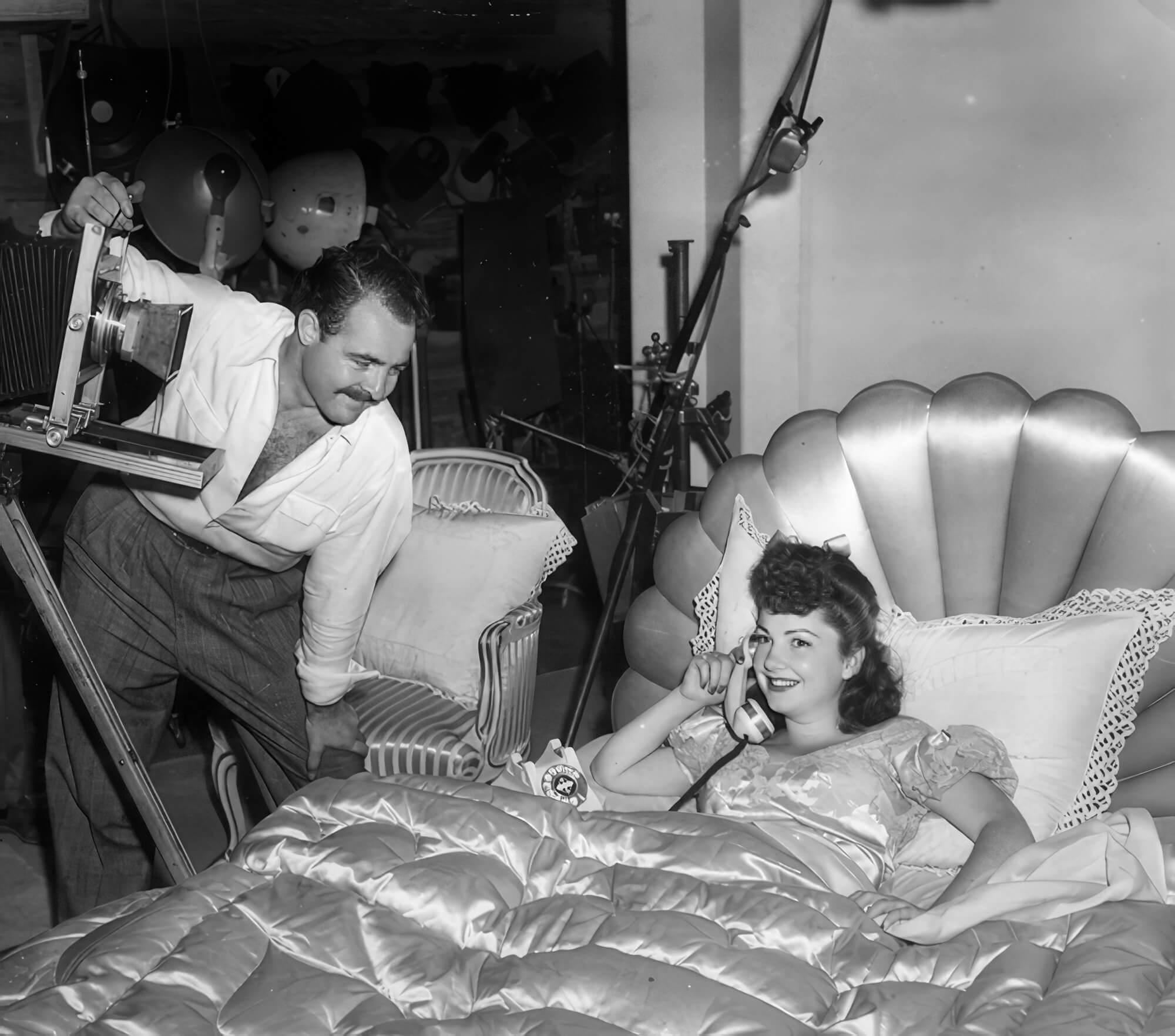 Tom Kelley on set with actress Anne Baxter, capturing a playful behind-the-scenes moment during a Hollywood studio shoot. Tom Kelley on set with actress Anne Baxter, capturing a playful behind-the-scenes moment during a Hollywood studio shoot.